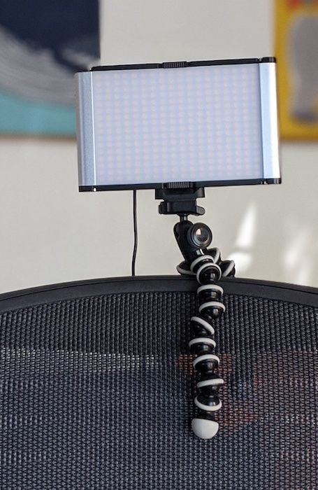 A LED video light attached to a chair's back with a Gorillapod.